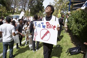 Protesters held signs with anti-police slogans.