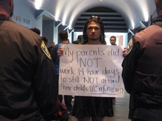 A student holds up a sign in opposition to increasing tuition prices.