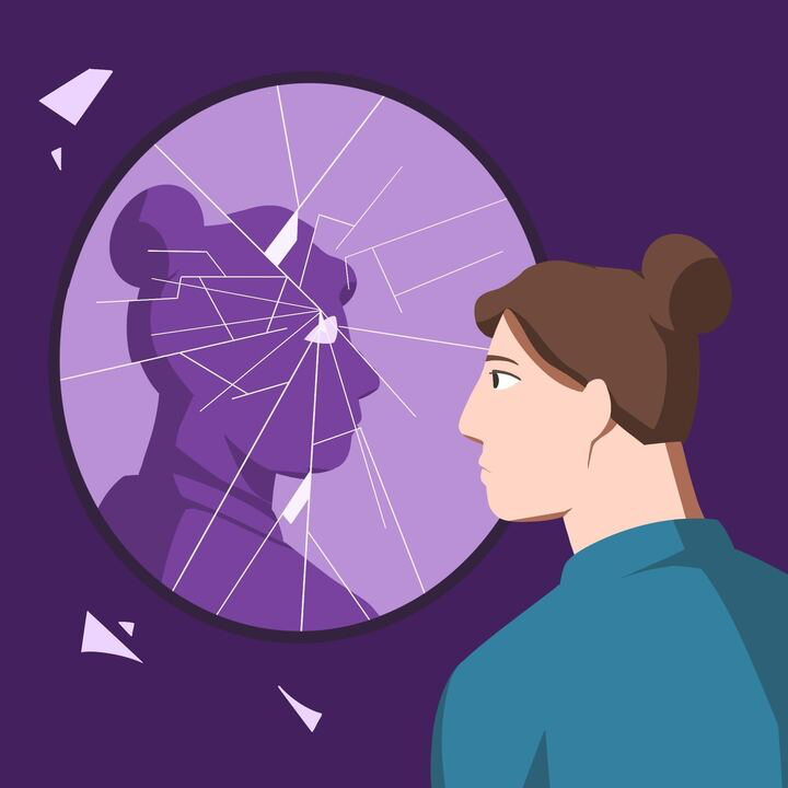 Person looking into a cracked mirror with a sad reflection of themselves.