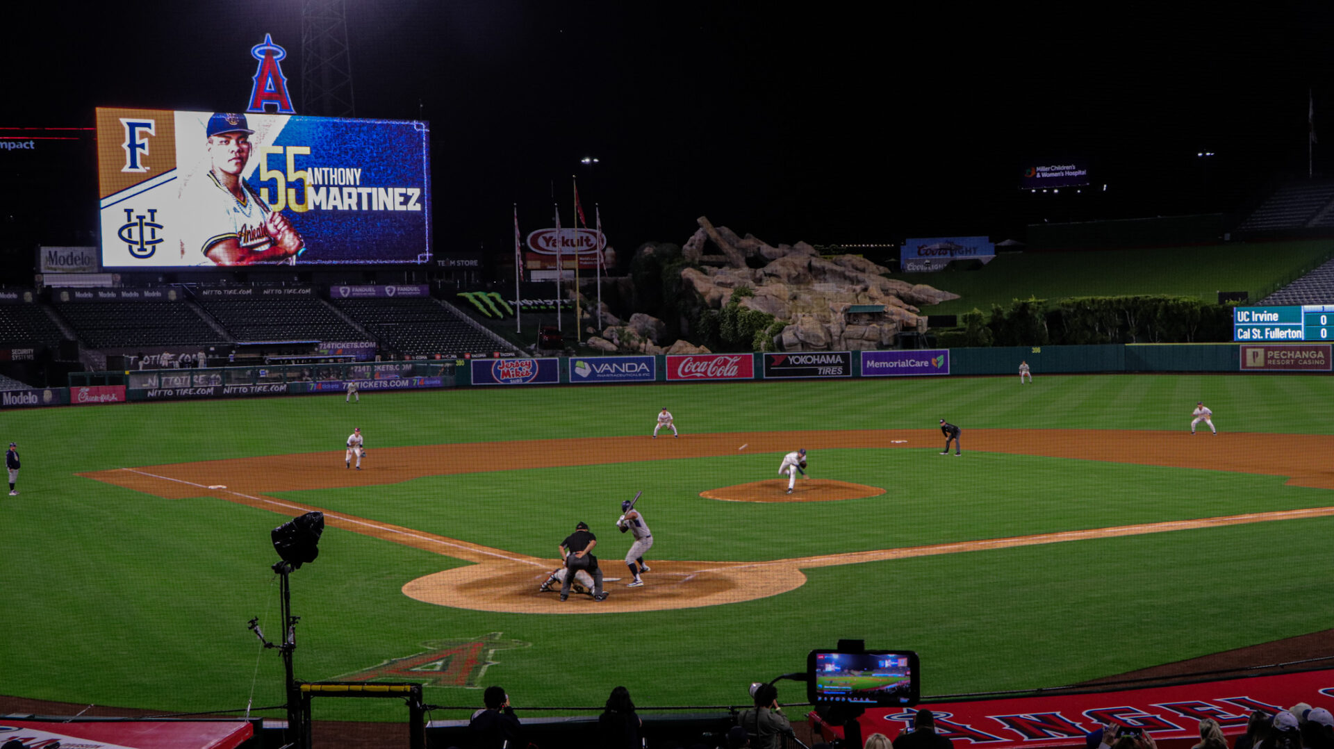 UC Irvine junior first baseman Anthony Martinez awaits a pitch from a Cal State Fullerton Pitcher. The video board with Martinez on it is in the top left corner