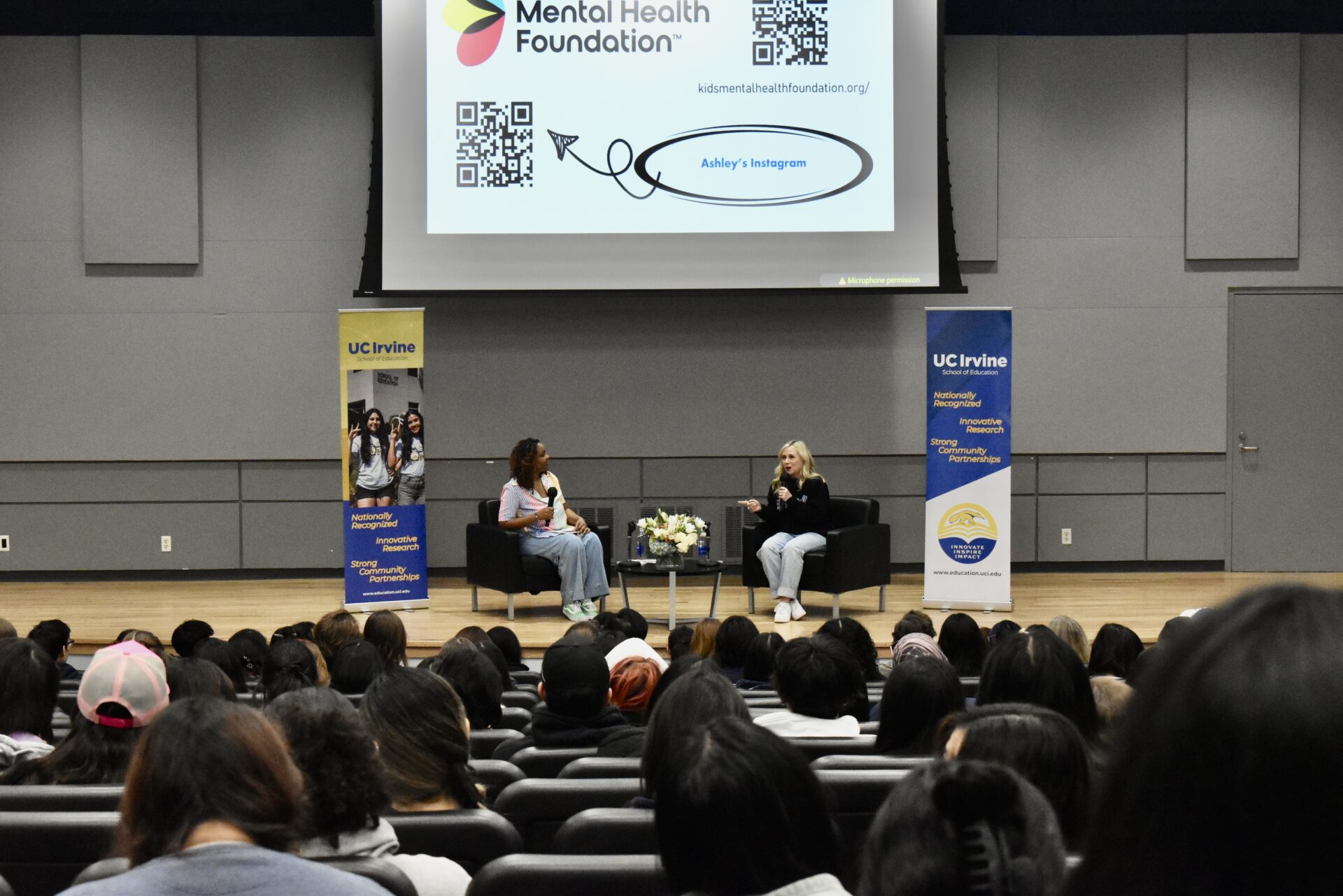 Wide shot of Ashley Eckstein and the interviewer speaking on stage in front of a full audience.