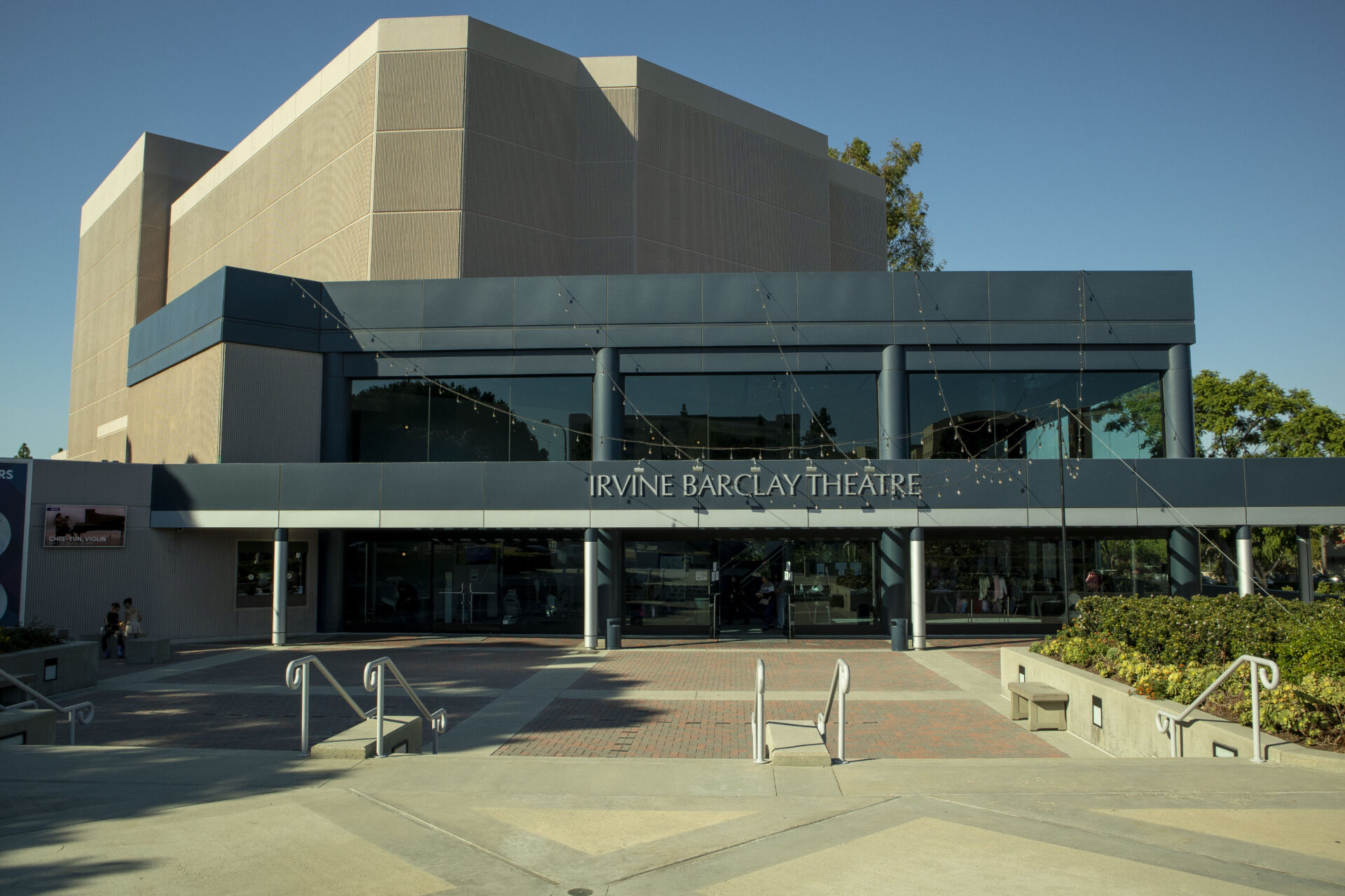 Wide shot of the front of the Irvine Barclay theatre with the stairs and planters in the foreground.