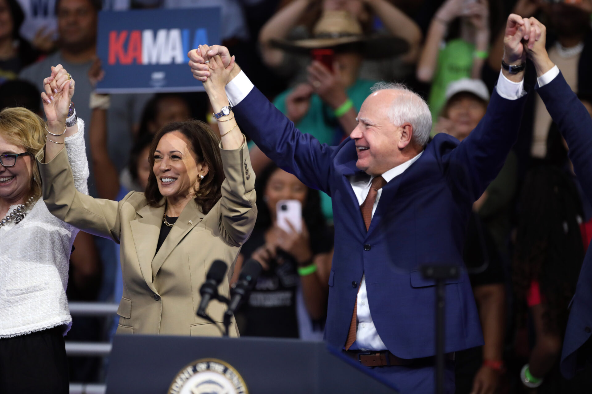 Vice President of the United States Kamala Harris and Governor Tim Walz speaking at a campaign rally at Desert Diamond Arena in Glendale, Arizona. Harris and Walz raise their hands up together at the rally.