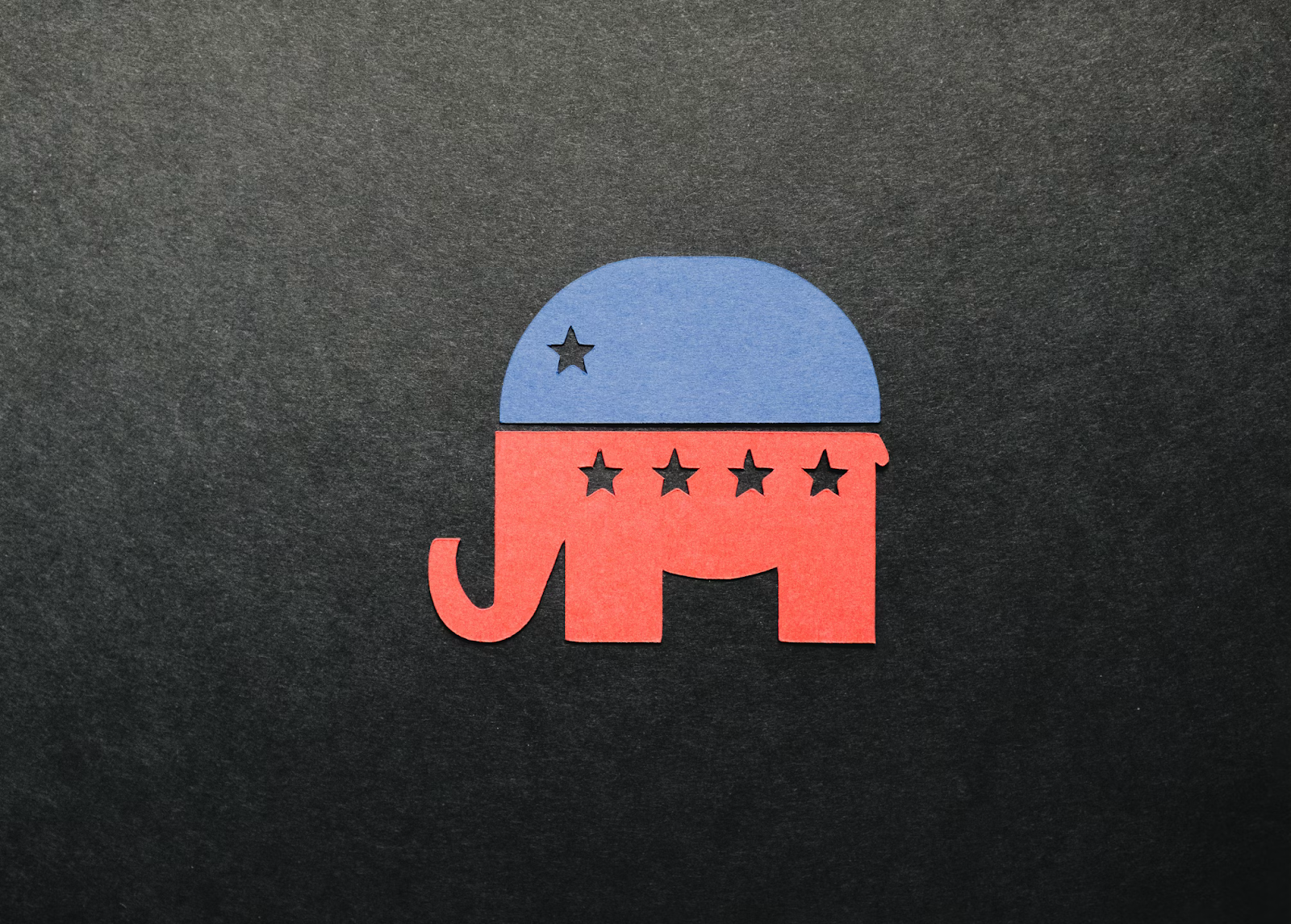 A paper GOP symbol is on laid out on a black background. The top is blue with one star and the bottom is red with four stars.