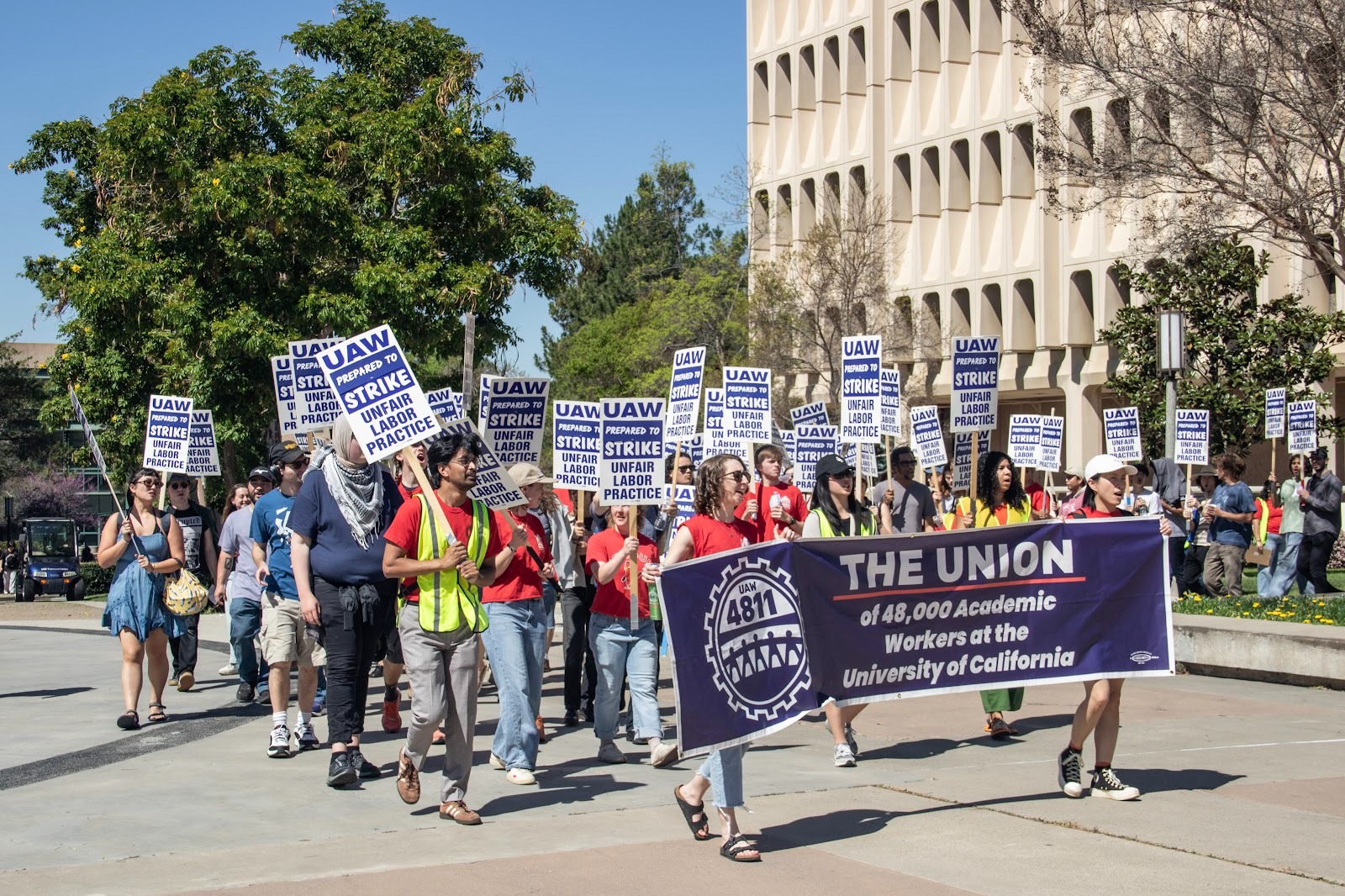 A group UAW members shown walking by Rowland Hall during a rally