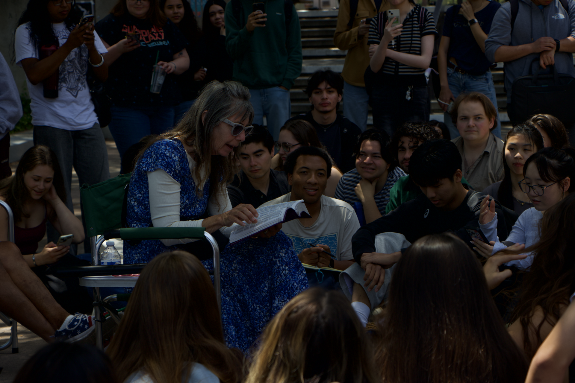 Sister Cindy is shown reading the Bible while students surround her