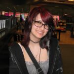 Juliana Rosie Maldonado in black glasses, a black jacket,] and crossbody black bag.