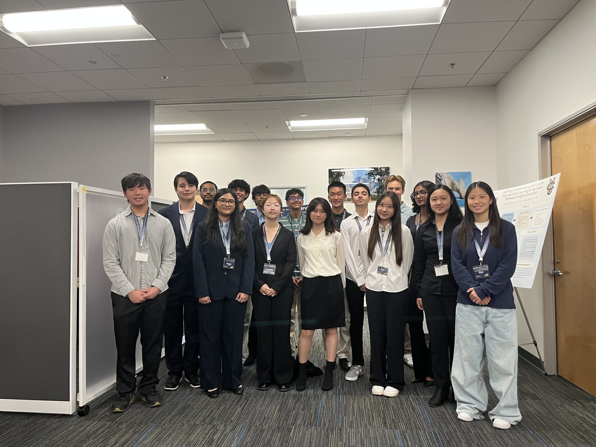 A group of high school students stand in a room together.