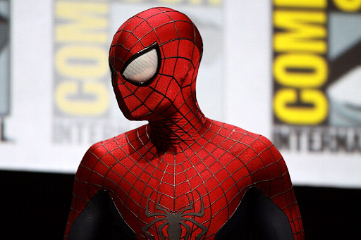 Red, white and black spiderman costume in-front of a yellow, white and black Comic-Con background